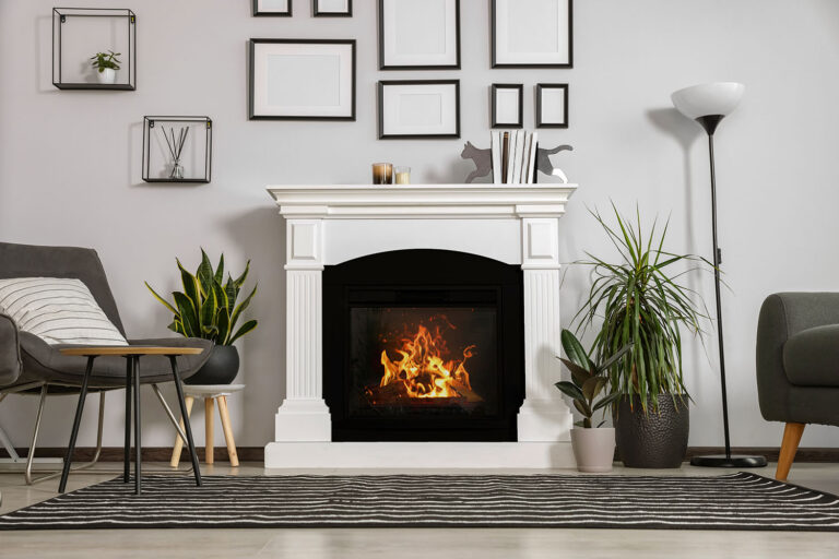 Stylish living room interior with fireplace, grey armchairs and side table
