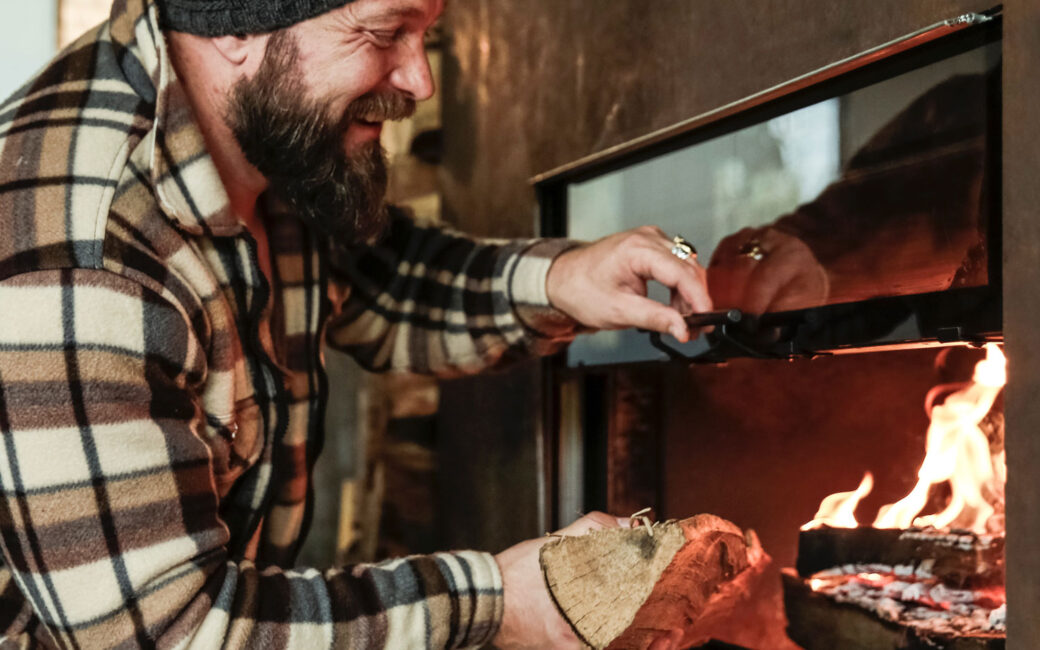 Man placing wood into fireplace