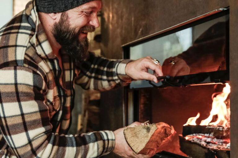 Man placing wood into fireplace